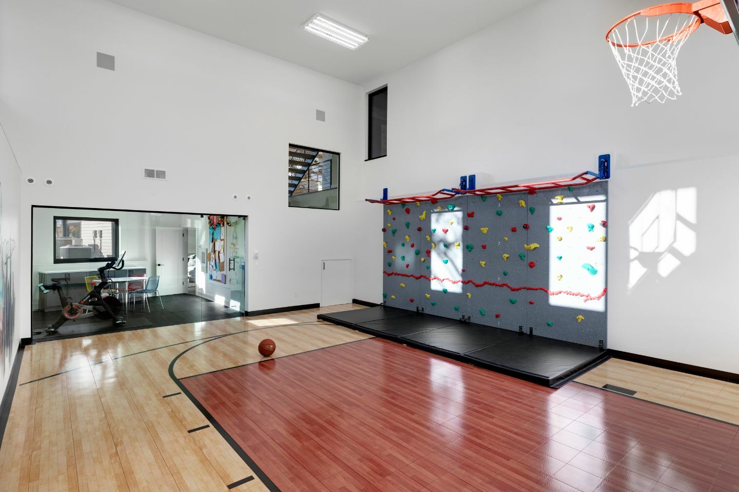 A separate exercise room looks into a sizable athletic court