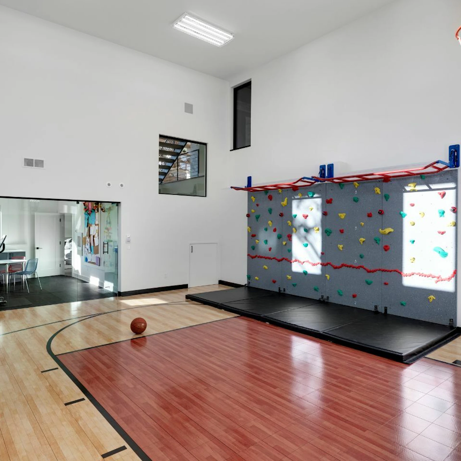 A separate exercise room looks into a sizable athletic court