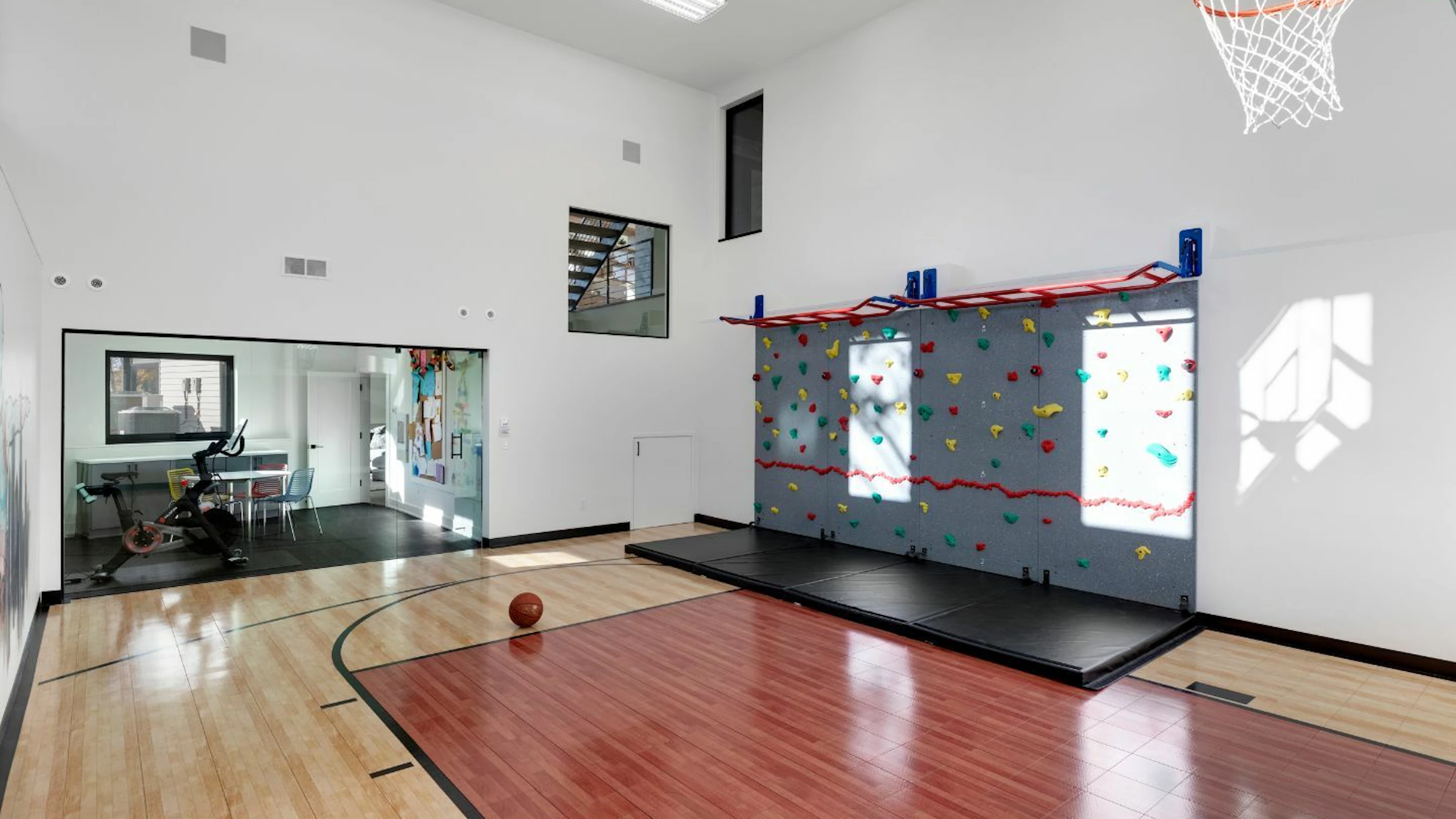 A separate exercise room looks into a sizable athletic court