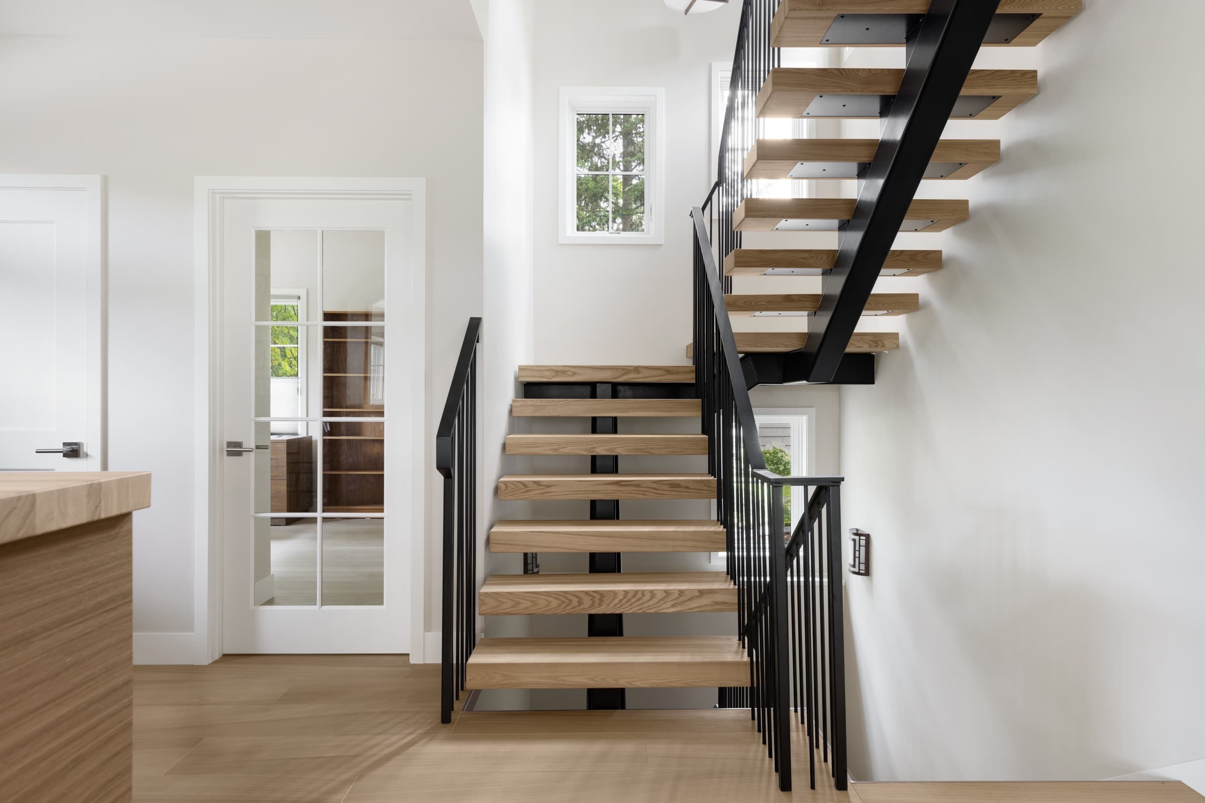 A floating steel staircase with white oak stair treads
