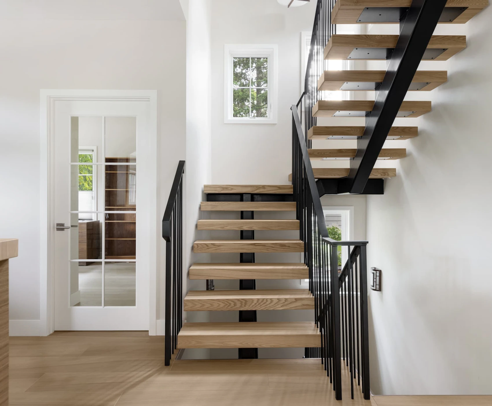 A floating steel staircase with white oak stair treads