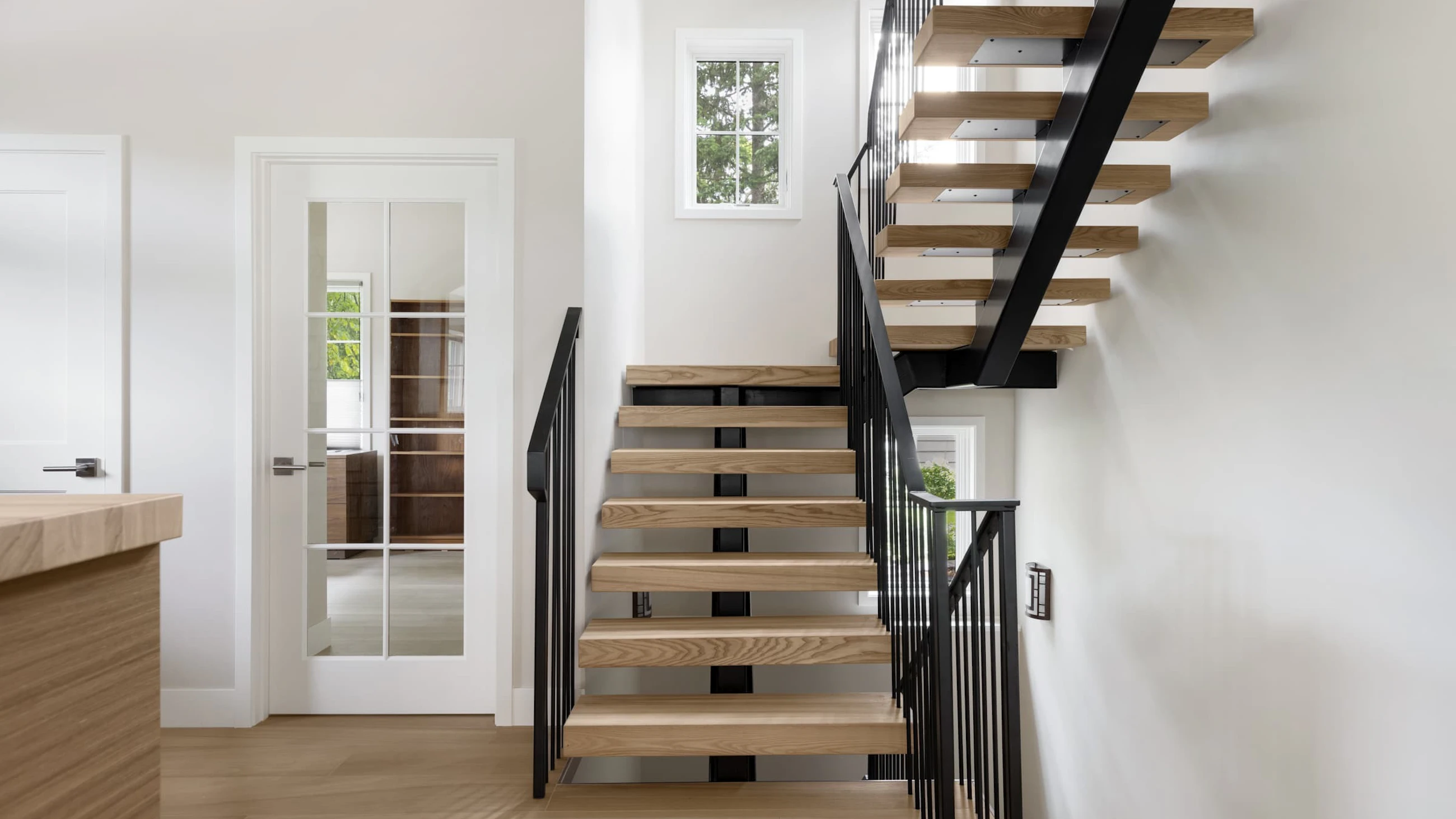 A floating steel staircase with white oak stair treads